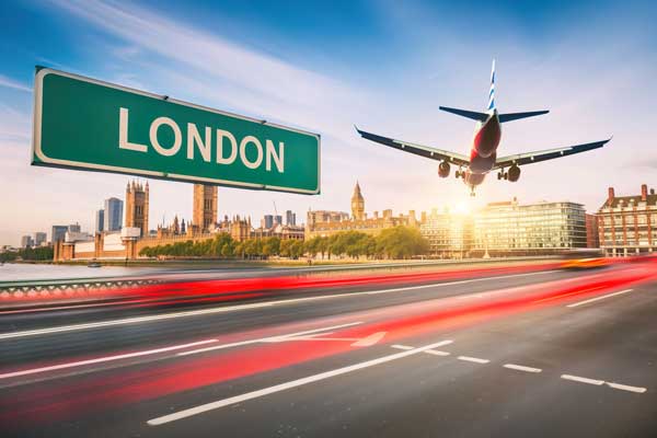 An aeroplane taking off over a London road sign